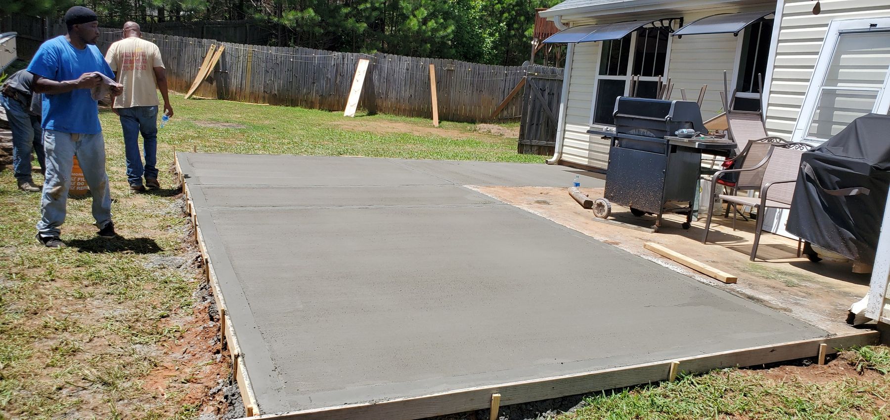 New backyard patio slab in the forms, crew standing at the edge