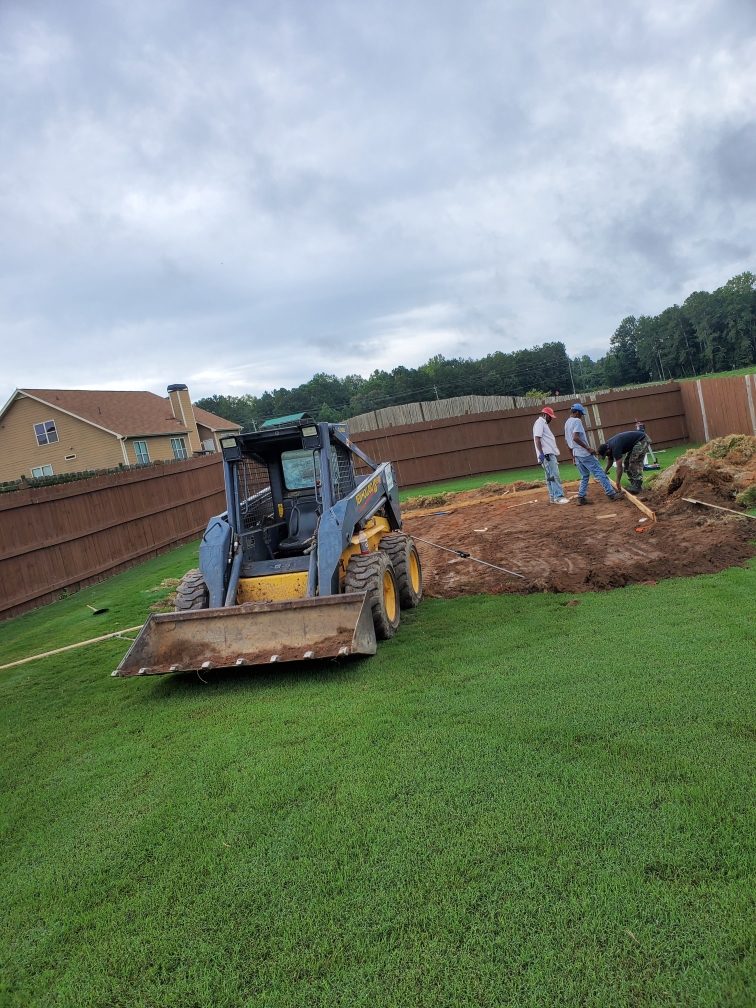 Hugh’s skid steer on a backyard job, with a rectangular patch of Georgia clay opened for a pour